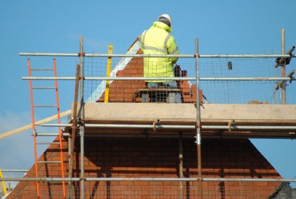 Man in high-vis jacket inspecting a roof