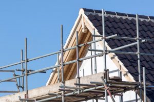 Modern house roof construction with scaffold pole platform. New build domestic building.